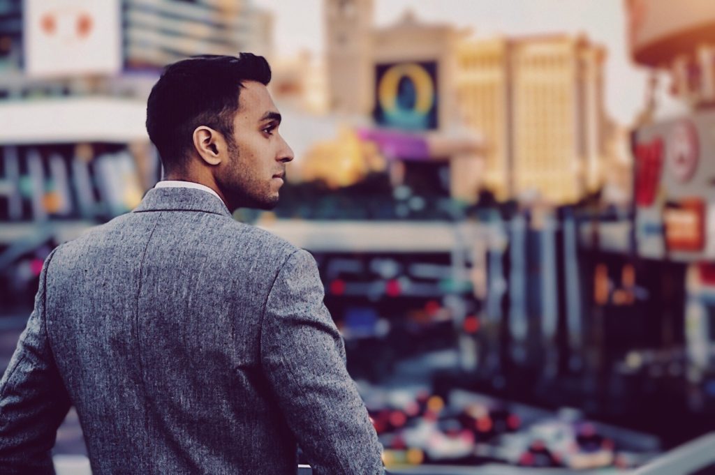 a profile of a man in gray blazer overlooking the strip.