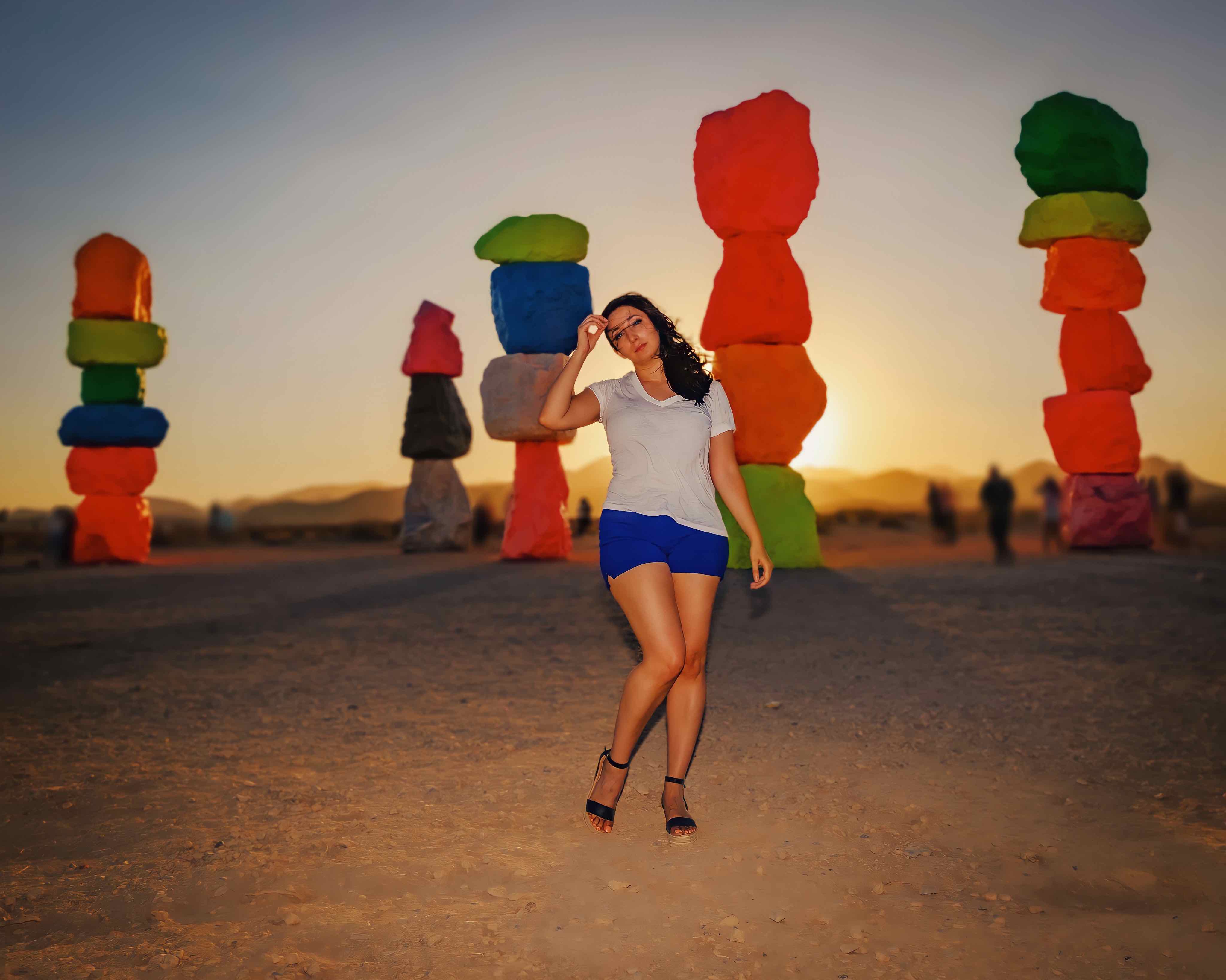 A woman standing in front of seven magic mountains 