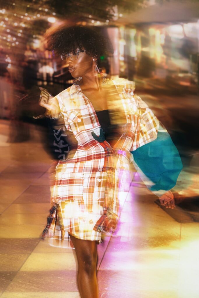 A woman confidently walking a fashion show runway wearing a modern casual outfit.