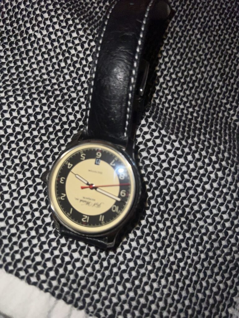 A blurry & harshly lit photo of a watch taken with a phone. Its purpose is to show the results of not hiring a professional photographer.